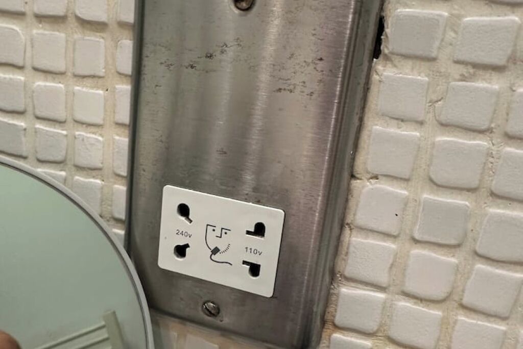 A wall socket with a label indicating 240v and 110v.