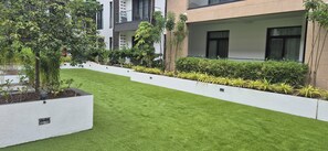 A modern building with a well-maintained lawn and various plants. - Ebs properties (Accra)