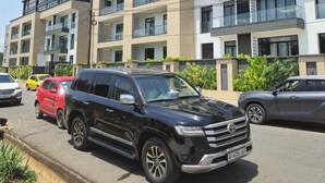 A multi-story residential building with balconies, a parking lot, and a clear sky. - Ebs properties  (Accra)