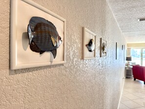 Stunning hallway with framed art pieces and a cozy room beyond.