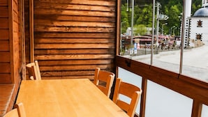 Puisesti sisustettu tila, jossa on suuri ikkuna, puinen pöytä ja tuolit.