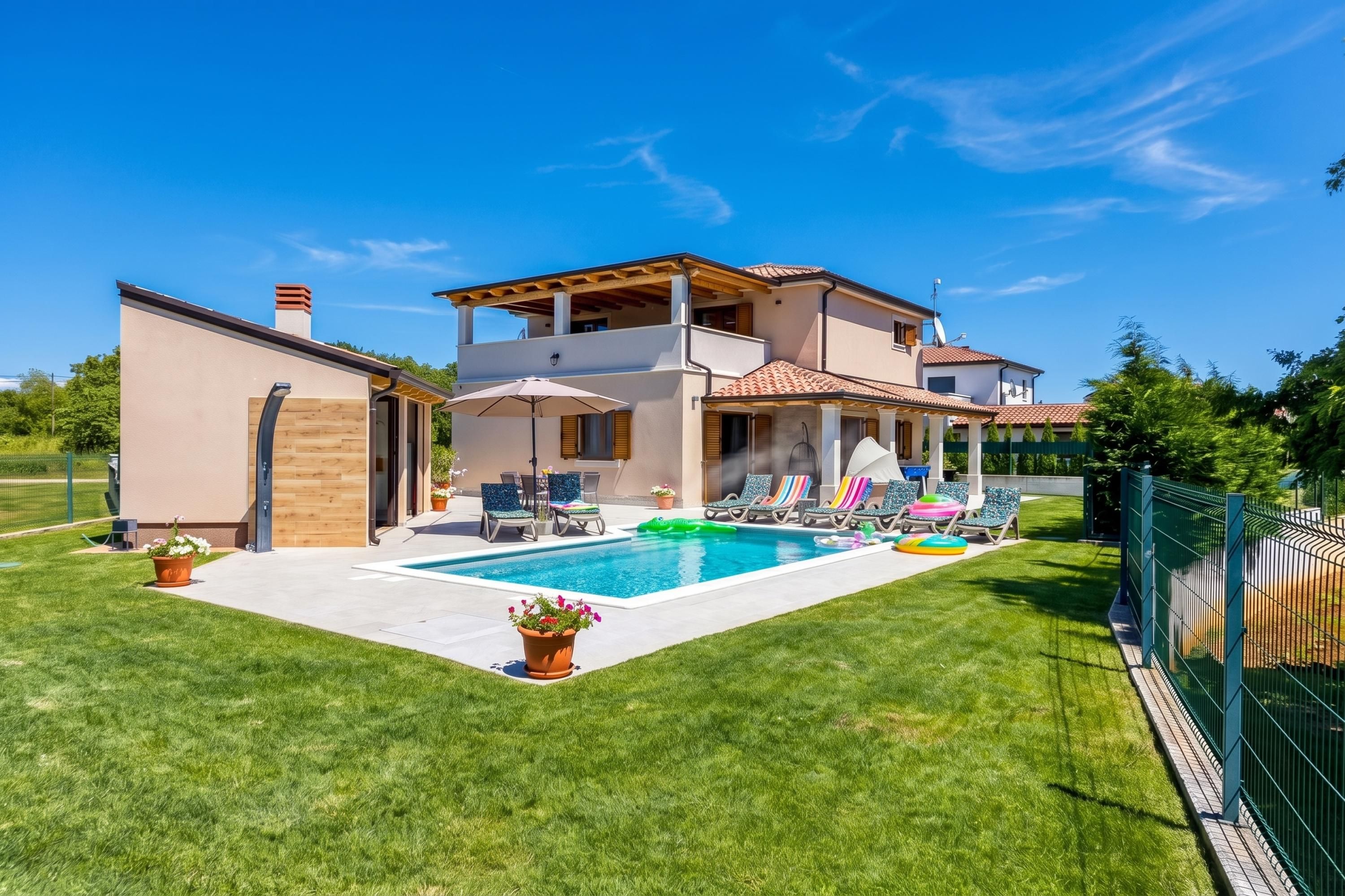 A two-story house with a swimming pool, outdoor seating, and a fenced yard.