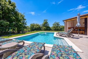 A swimming pool with lounge chairs and a covered seating area. - Pool and Fun Villa Stella Klarici (Svetvincenat)
