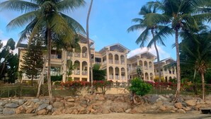 Ein Resort mit mehrstöckigen Gebäuden, Balkonen und tropischer Bepflanzung.