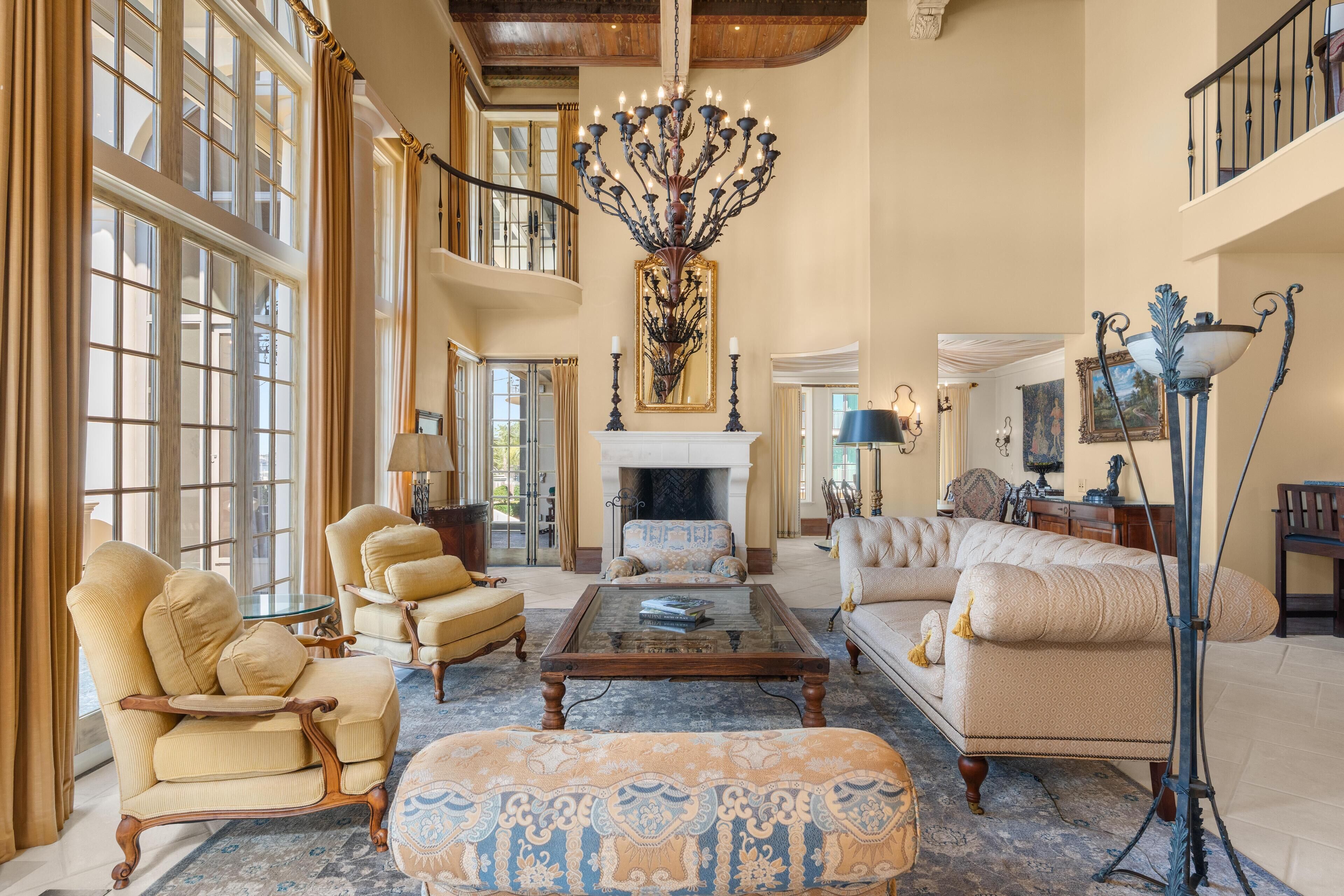 A spacious living room with a fireplace, large windows, and elegant furniture.
