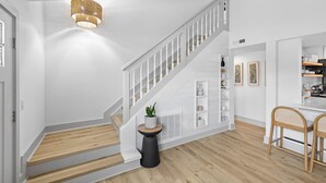 A staircase with white railings and a black base, leading to a dining area with wicker chairs and a white table. - Bring your boat/Pool/Kayaks/Arcades (Hernando Beach)