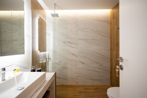Een moderne badkamer met een grote spiegel, een witte wasbak en een douchehoek.