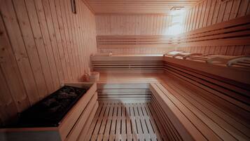 Una sauna con bancos de madera y suelo central calefaccionado.