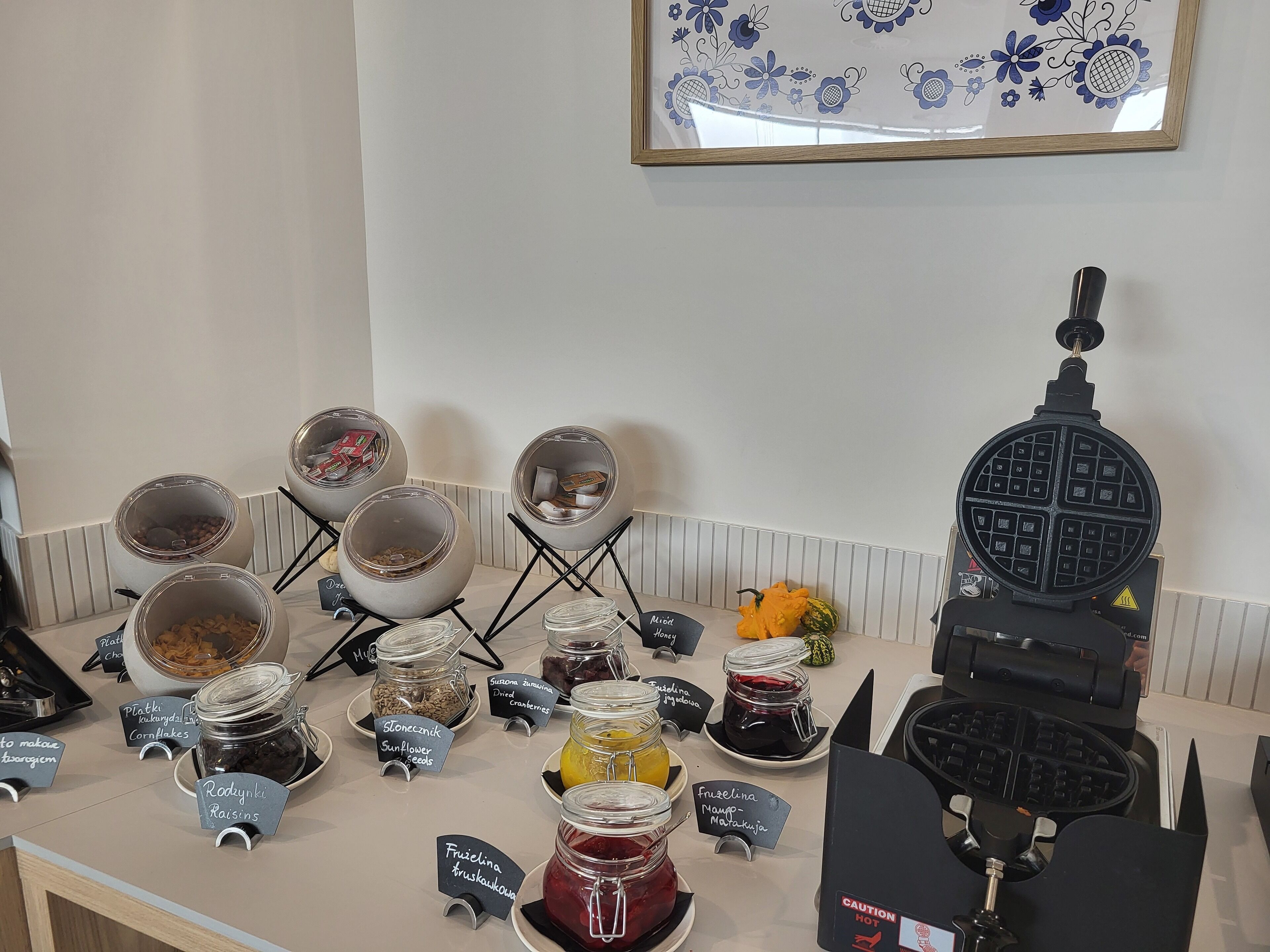 A breakfast buffet with various food items and a waffle maker.