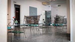 A hotel lobby with a reception desk, a private room sign, and a large clock on the wall. - Hotel Fattori (Cesenatico)