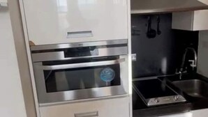 Uma cozinha com forno embutido, fogão e pia.