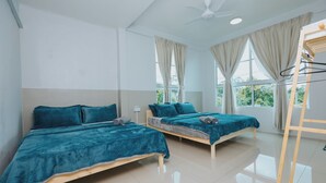 Camera da letto moderna con due letti, una ventola a soffitto e ampie finestre con tende.