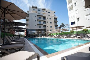 Una piscina al aire libre, sombrillas