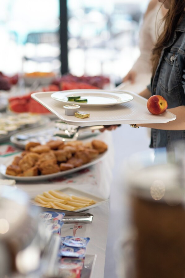 A buffet table with various food items and condiments. - Hotel Apart Resilient (Golem)