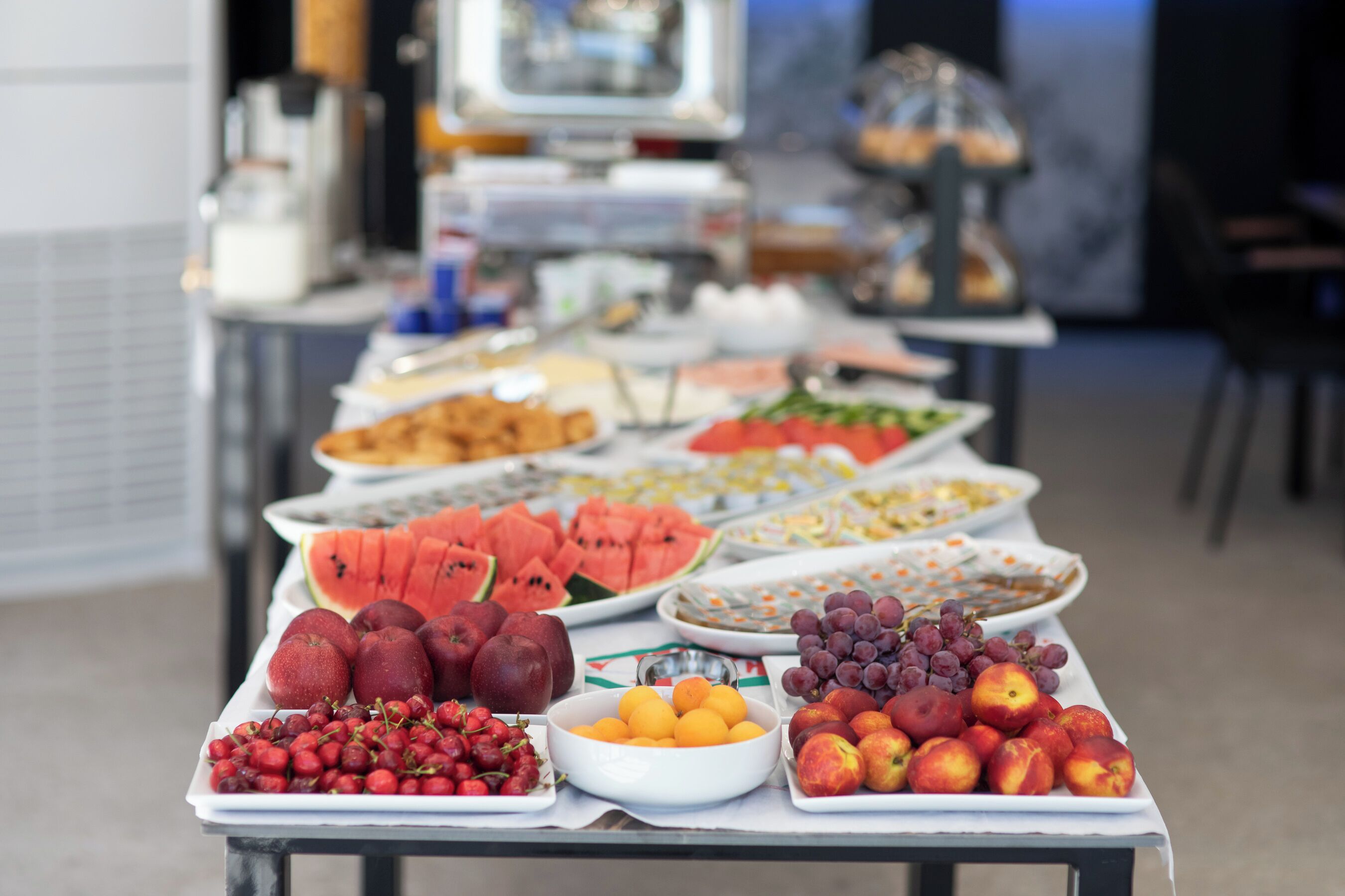 A buffet table with various fruits and dishes.