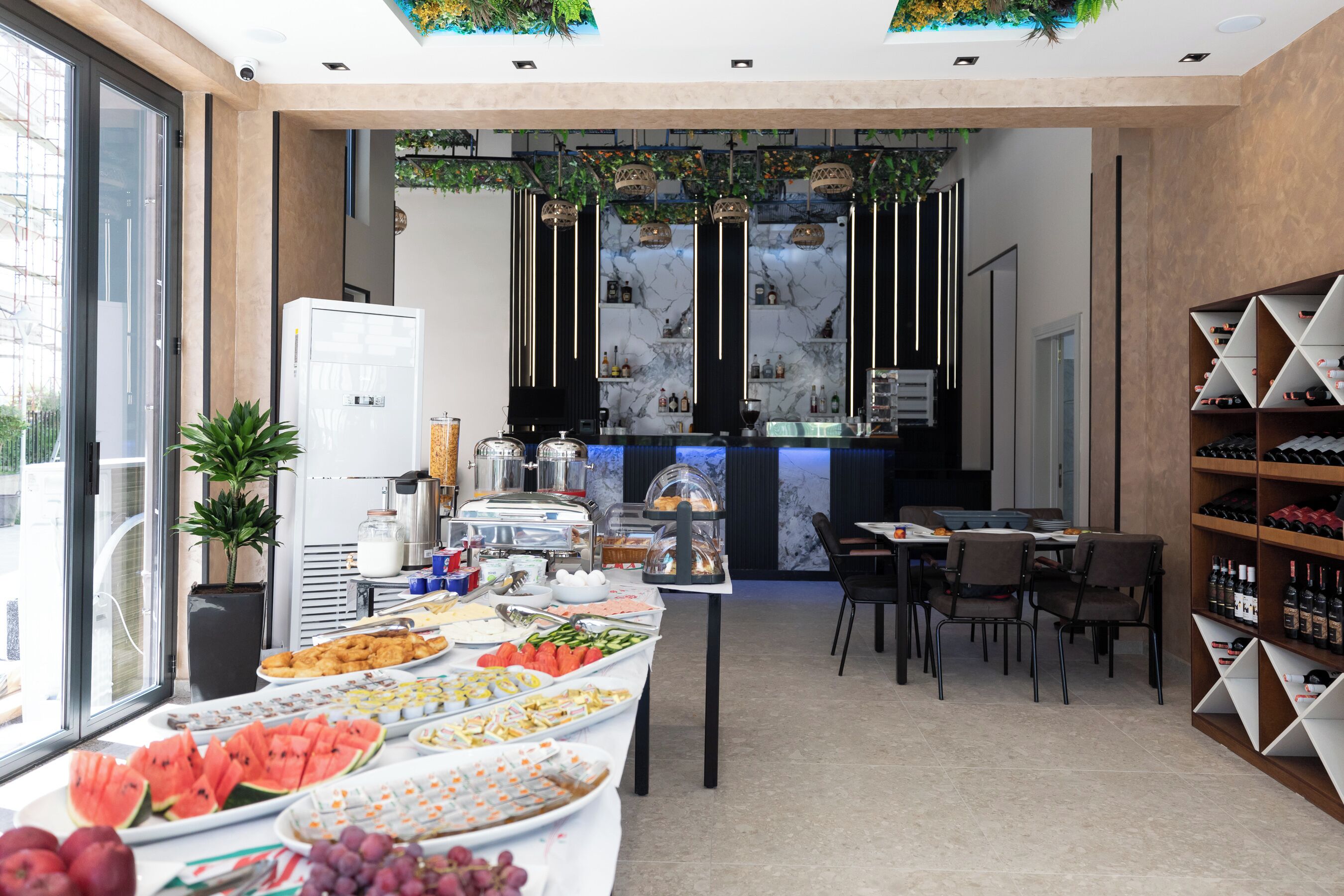 A modern breakfast area with a buffet, seating, and a wine rack.