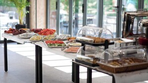 A buffet table with various food items and a coffee machine.