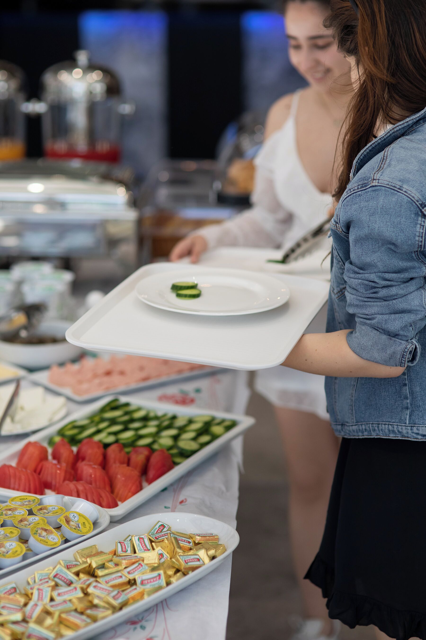 Una mesa de buffet con diversas opciones de comida y una persona sirviendo.