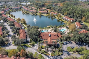 A residential area with a lake, a swimming pool, and a fountain.
