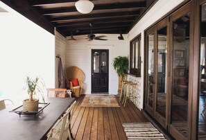 Step into a serene outdoor space with a cozy seating area, wicker chair, and potted plant.