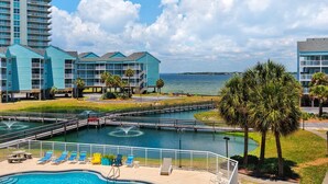 A resort with a swimming pool, lounge chairs, and a view of the ocean. - Baywatch G5 (Pensacola Beach)