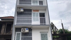 A multi-story building with balconies and an air conditioning unit. - David Houses (Nusa Dua)
