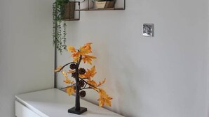 A white dresser with a decorative autumn-themed branch with leaves and pinecones on top. - Stylish & Spacious 1 bed flat next to station (London)