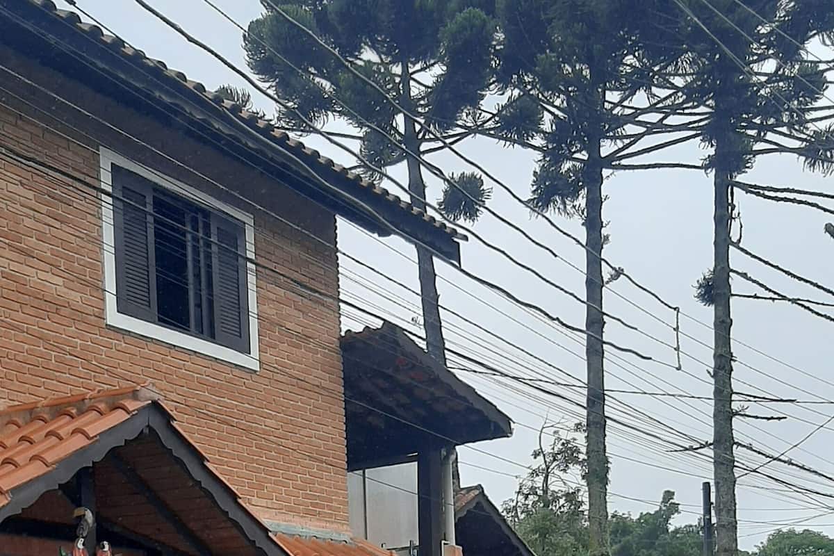Une maison à deux étages, avec un toit en tuiles, un mur en pierre et un portail en métal.
