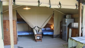 A compact room with two beds, a small table, a refrigerator, and a canopy bed. - Camping de l'Aigle (Aiguines)