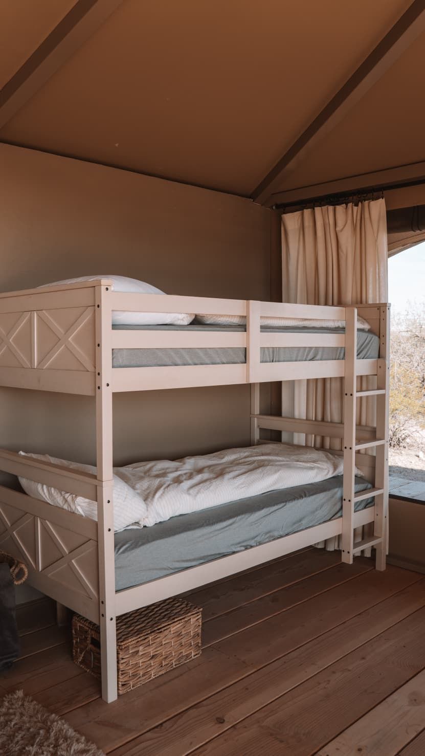 Ein Etagenbett in einem Zimmer mit Holzboden und einem Vorhangfenster.