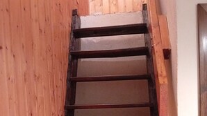 Eine Holztreppe mit dunkler Metallhandläufer, die in eine untere Ebene führt.