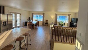 A spacious living area with a kitchen, dining area, and a staircase leading to another level. - Enchanting whole home on Nancy lake with WiFi in Willow Alaska! (Willow)