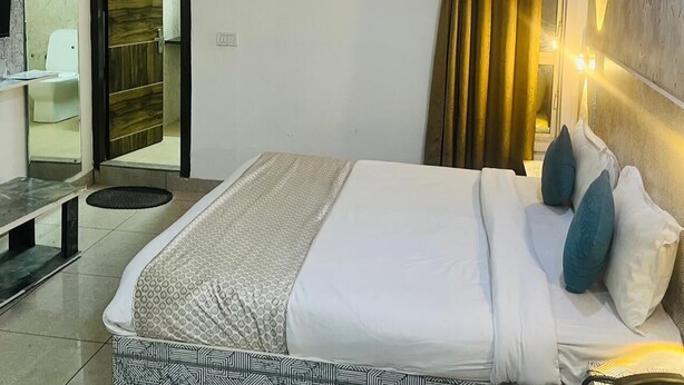 Hotelkamer met een bed, bureau, spiegel, badkamer en een airconditioning.