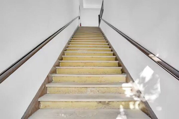 Una escalera de madera con barandillas de metal que asciende.