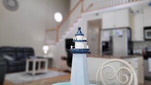 A model lighthouse in a room with a staircase and a television in the background. - Spacious 3 Bed/2 Bath, Sleeps 8 in Ocean Lakes!! (Myrtle Beach)