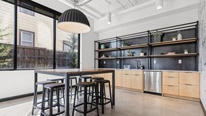 Una cocina moderna con una isla central, taburetes de bar y estanterías empotradas.