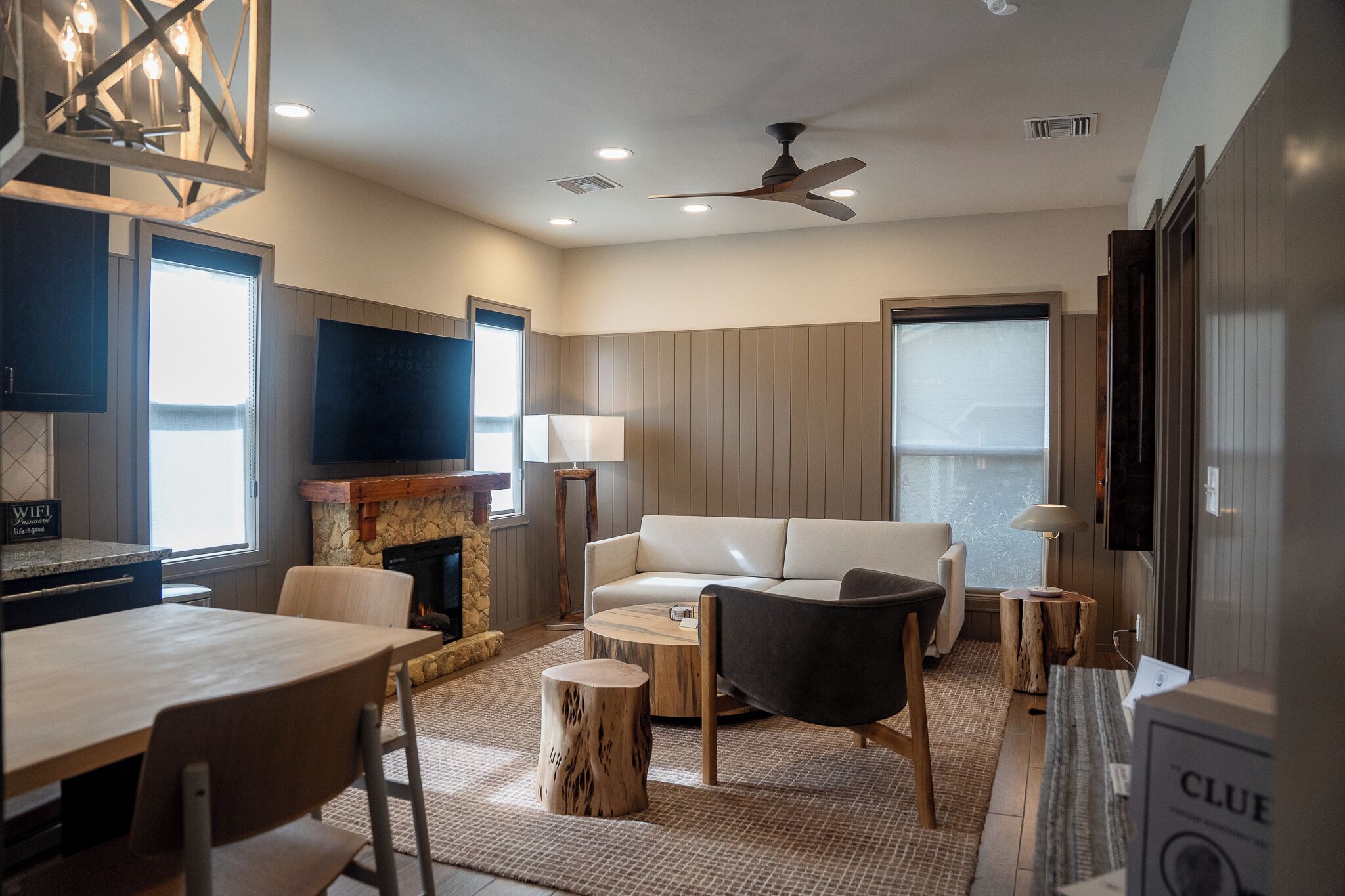 A modern living room with a fireplace, a sofa, a dining table, and a TV.