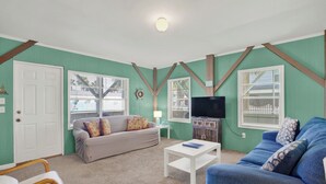 A living room with a sofa, a coffee table, and a television.