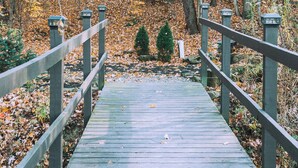 A wooden bridge in a forest with yellow leaves. - Charming cabin for 2, with private hot tub and peaceful creek (Beach City)