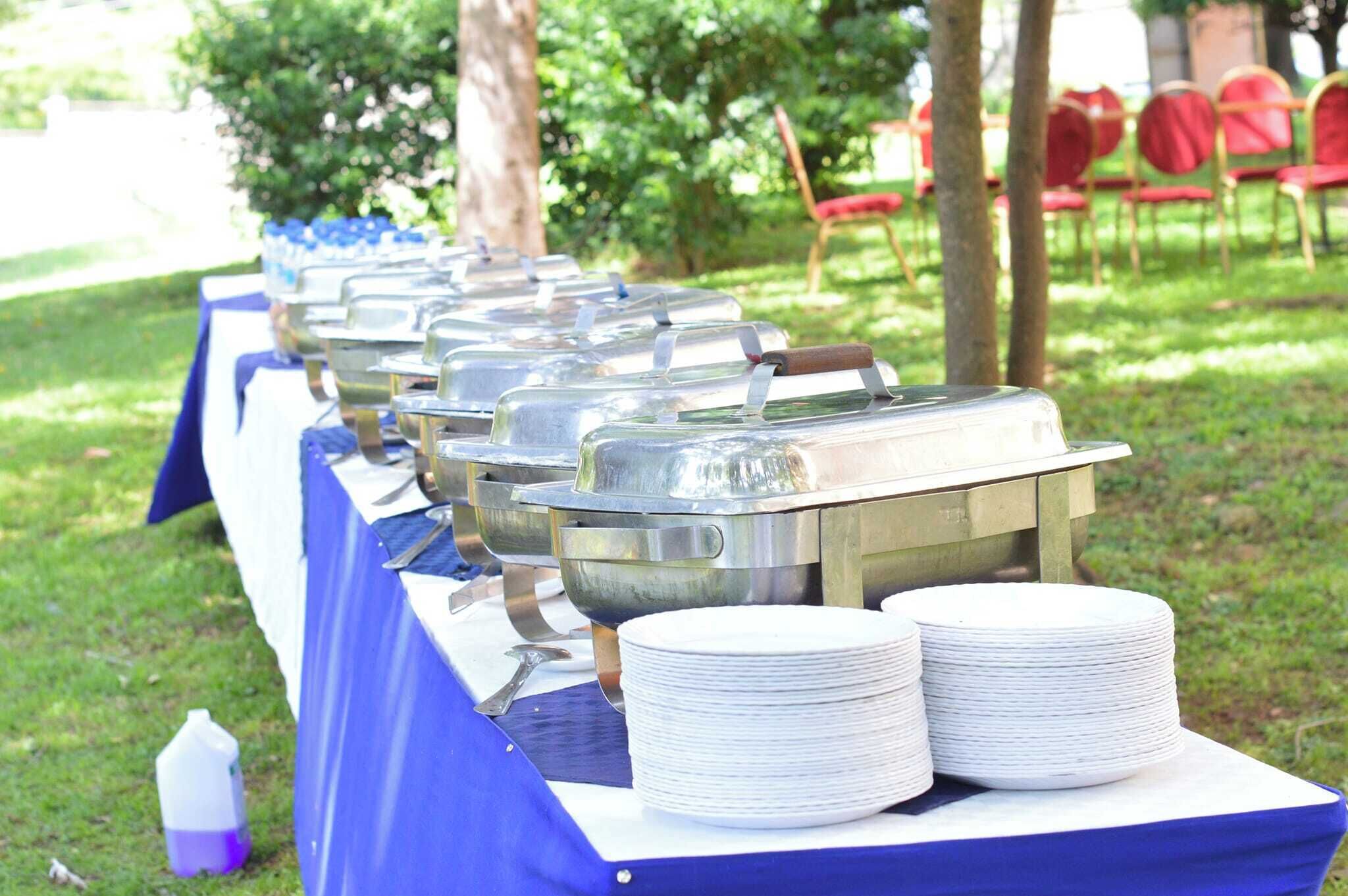 Un buffet avec plusieurs points de service et des piles d’assiettes blanches.