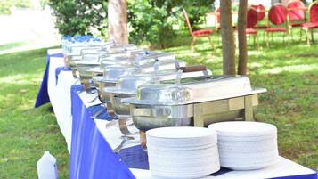 Un buffet avec plusieurs points de service et des piles d’assiettes blanches.