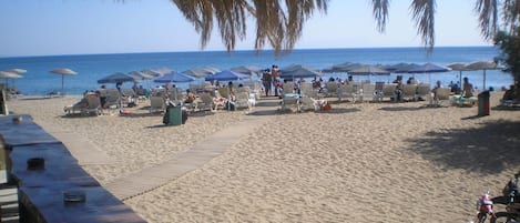 Aan het strand, ligstoelen aan het strand, parasols, beachvolleybal