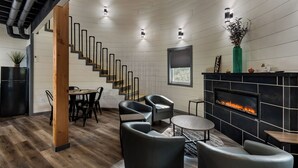 Un salon moderne avec une cheminée, un escalier et un coin repas.