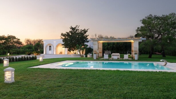 Une villa moderne dotée d’une piscine, d’un espace salon extérieur et d’une pergola.
