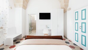 Une chambre moderne équipée d’un lit, d’une télévision, d’une salle de bain et d’une armoire.