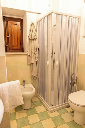 Une salle de bain équipée d’une douche, d’un bidet et de toilettes.
