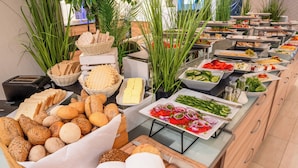 A buffet with various breads, cheeses, and vegetables. - Green Garden Hotel (Falenty)