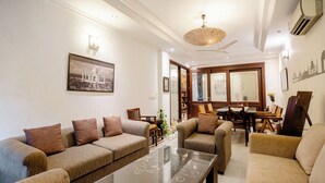 Una sala de estar con sofás, una mesa de centro y un comedor con sillas y una mesa.