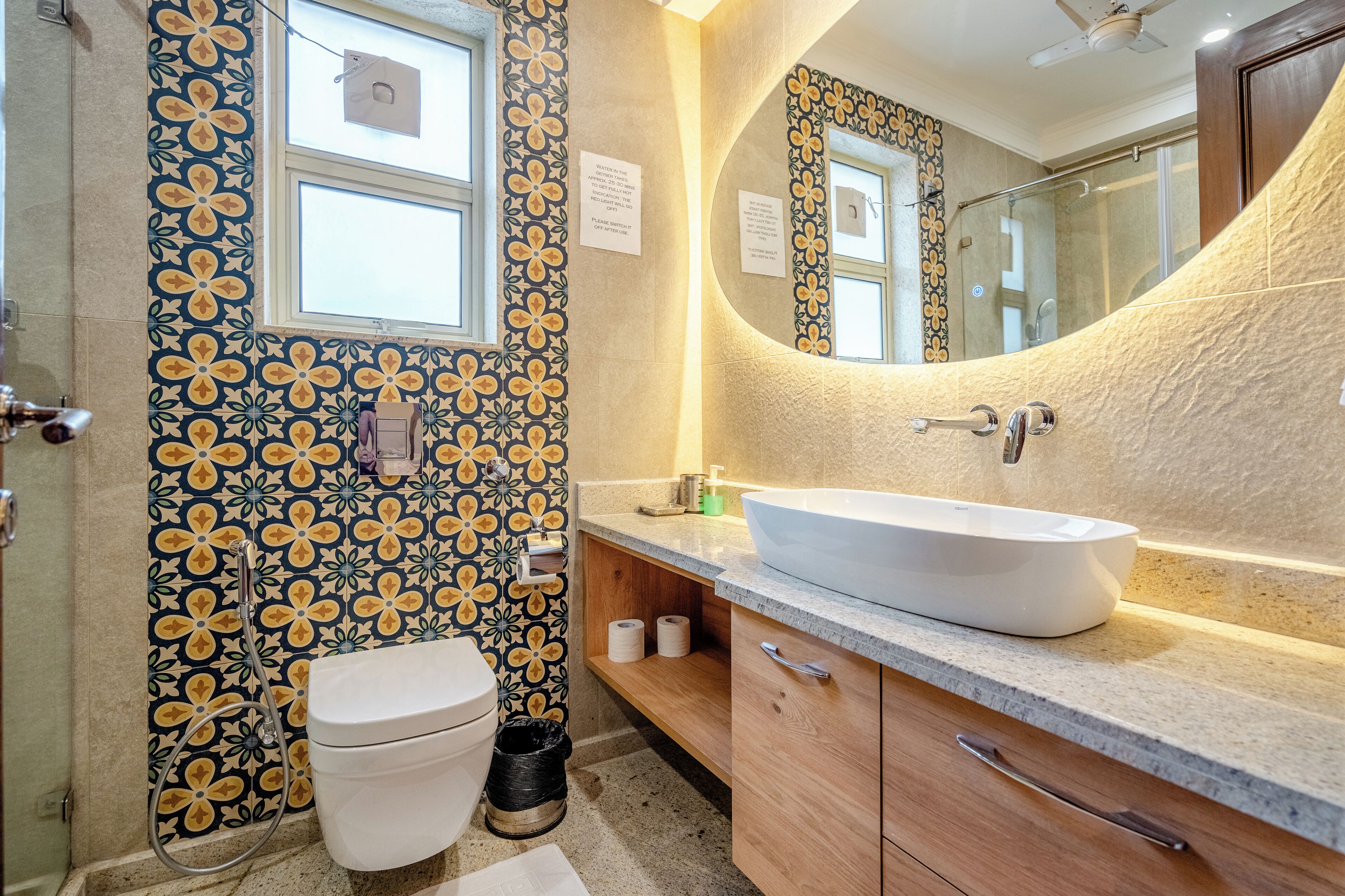 A bathroom with a large white sink, a mirror, and a toilet.