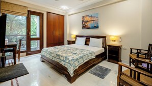 Un dormitorio con una cama grande, muebles de madera, un cuadro en la pared y vistas a través de una puerta.